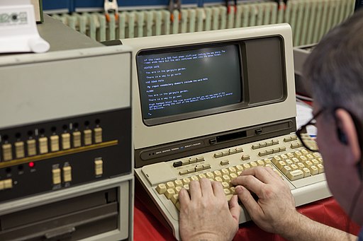 A picture of a man with glasses using an old terminal display from 1978